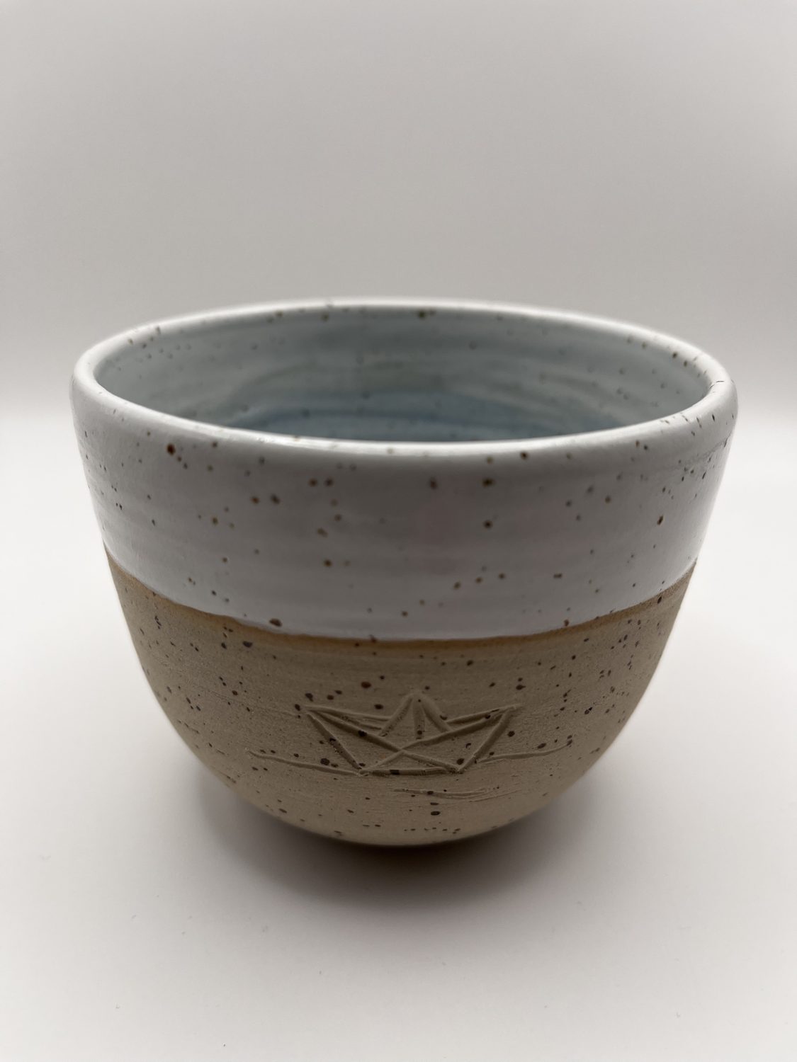 Handgetöpferte Schale mit eingeritztem Papierboot und weiß-blauer Glasur